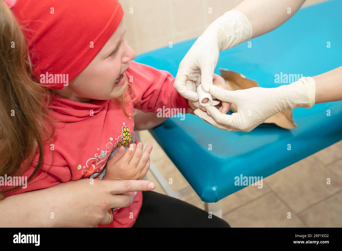 Les mains du médecin bandent le doigt douloureux avec un bandage de l'enfant.Blessure et blessure au doigt chez les enfants Banque D'Images