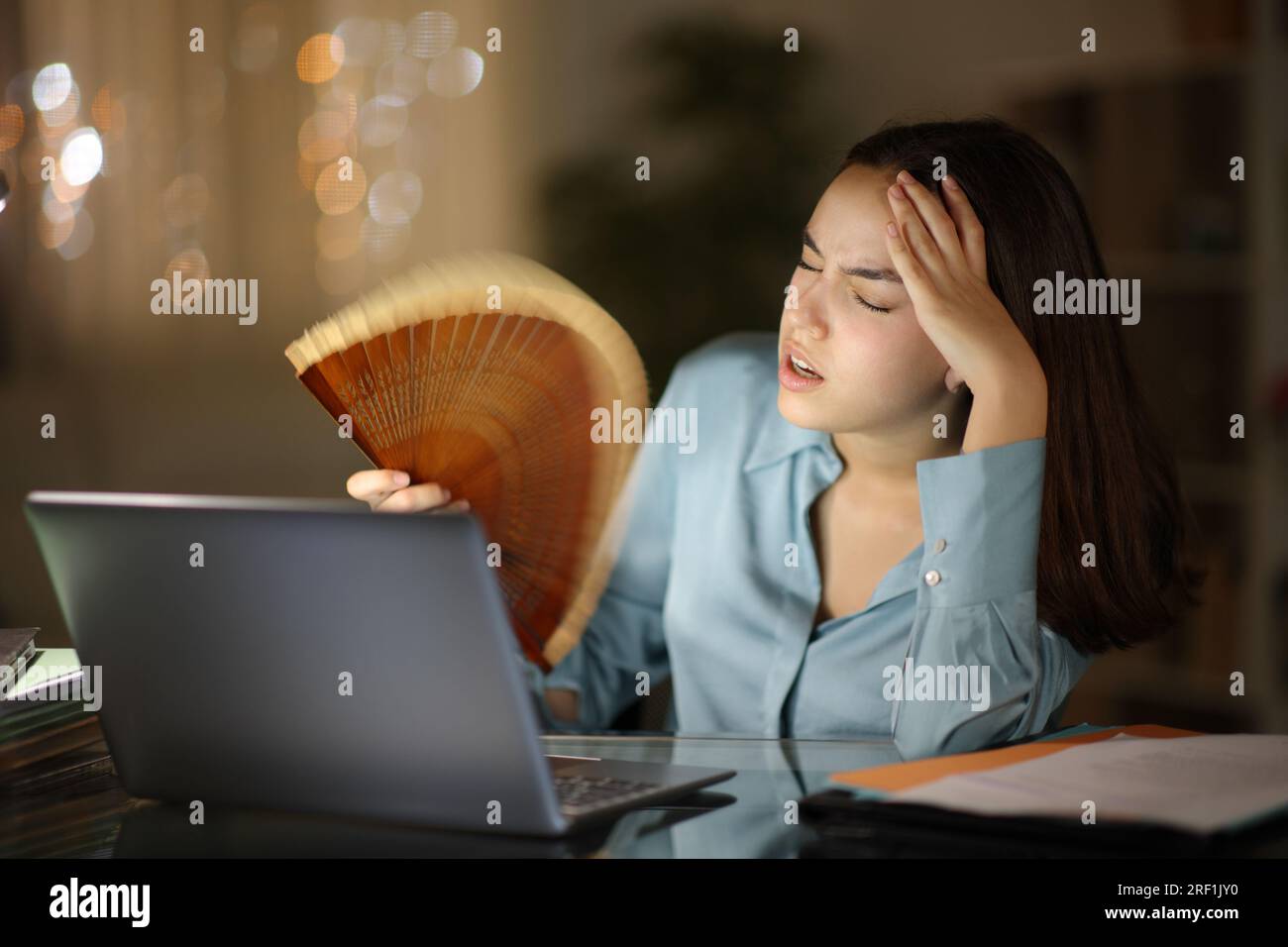 Travailleur indépendant stressé souffrant d'un coup de chaleur et travaillant la nuit à la maison Banque D'Images