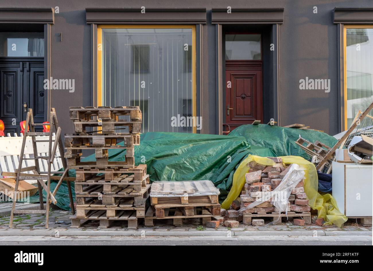 Matériaux de construction, échelles en bois, palettes Euro et déchets encombrants sur le bord de la route Banque D'Images
