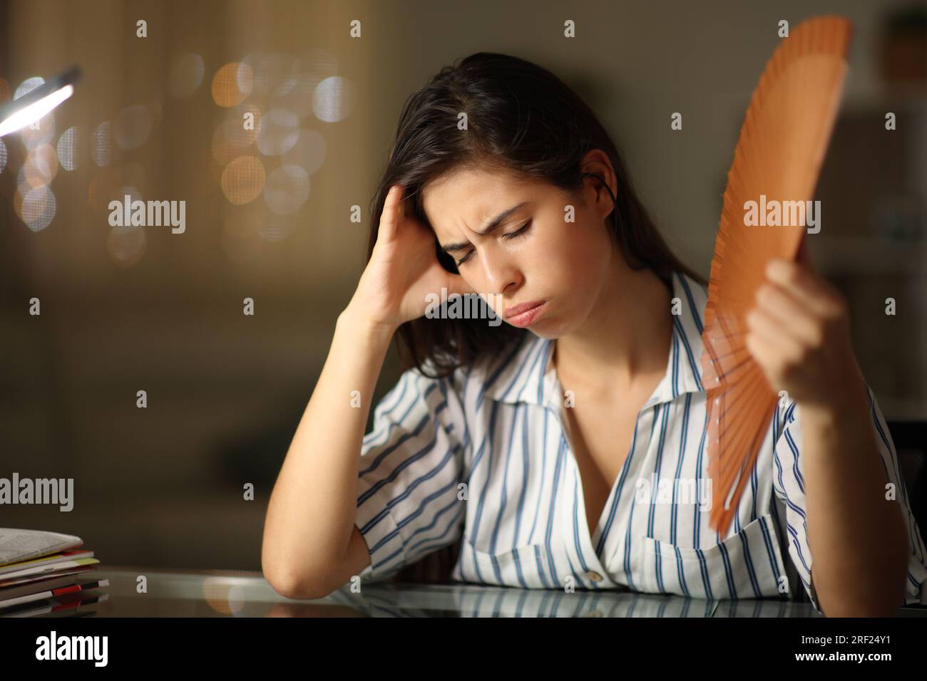 Femme stressée se fanant à la maison pendant le coup de chaleur dans la nuit Banque D'Images