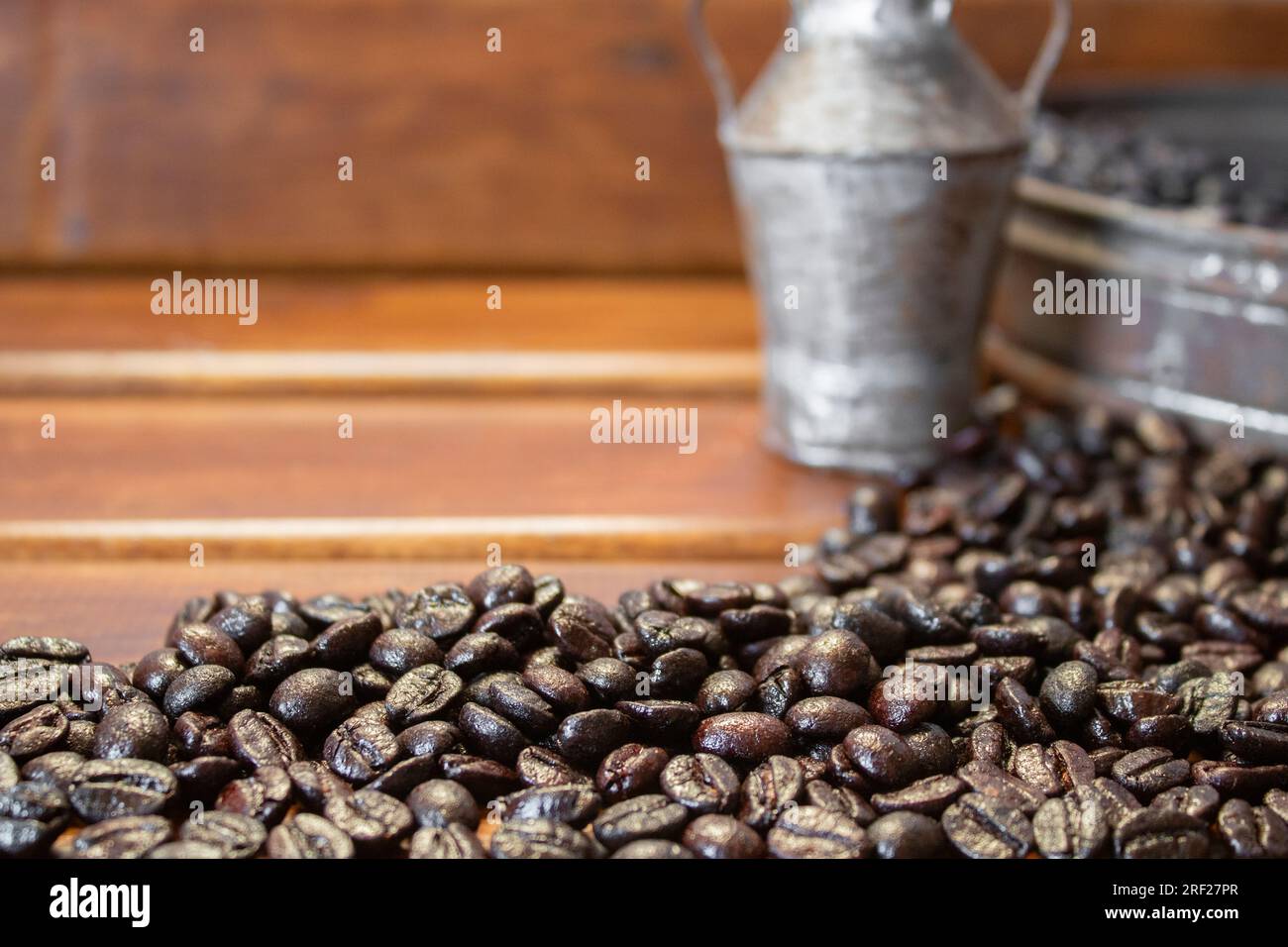 grains de café sur fond en bois non focalisé, avec espace pour la copie et une carafe et un panier en étain antique Banque D'Images