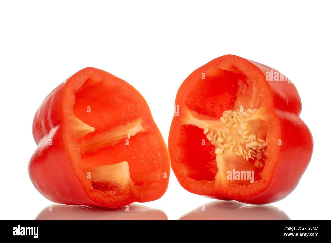 Deux moitiés de poivron rouge doux, macro, isolé sur fond blanc. Banque D'Images