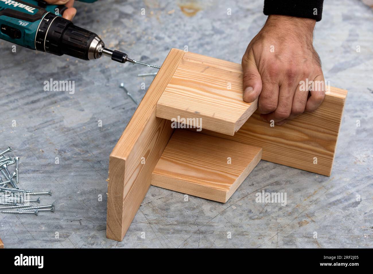 fabrication d'une mangeoire pour les écureuils, étape 4 : les latéraux sont fixés sur la plaque de base, image de série 4/13 Banque D'Images