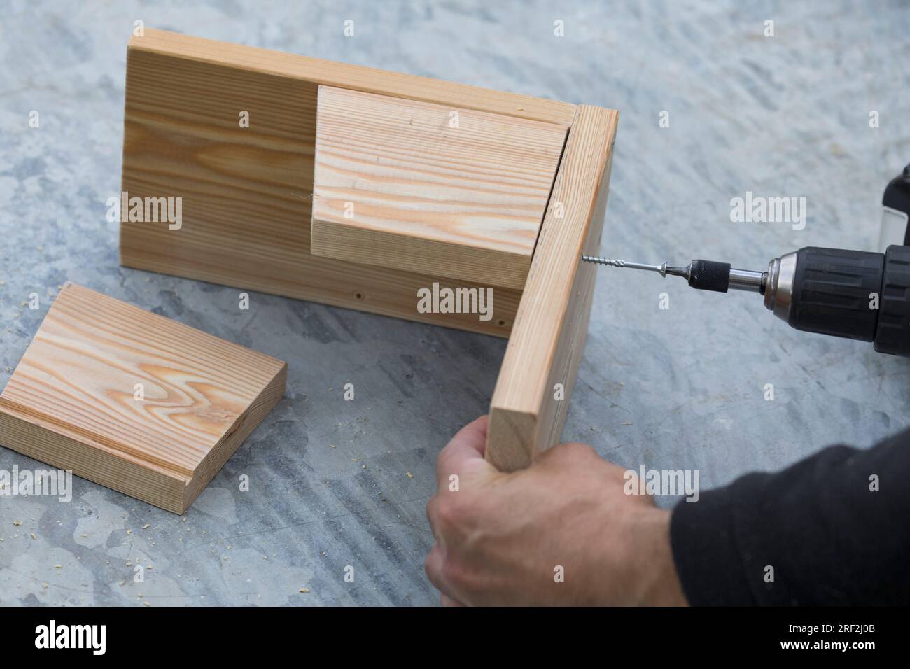 fabrication d'une mangeoire pour les écureuils, étape 4 : les latéraux sont fixés sur la plaque de base, image de série 4/13 Banque D'Images