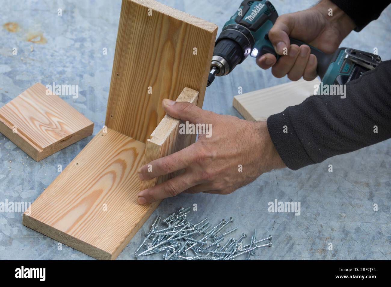fabrication d'une mangeoire pour les écureuils, étape 4 : les latéraux sont fixés sur la plaque de base, image de série 4/13 Banque D'Images