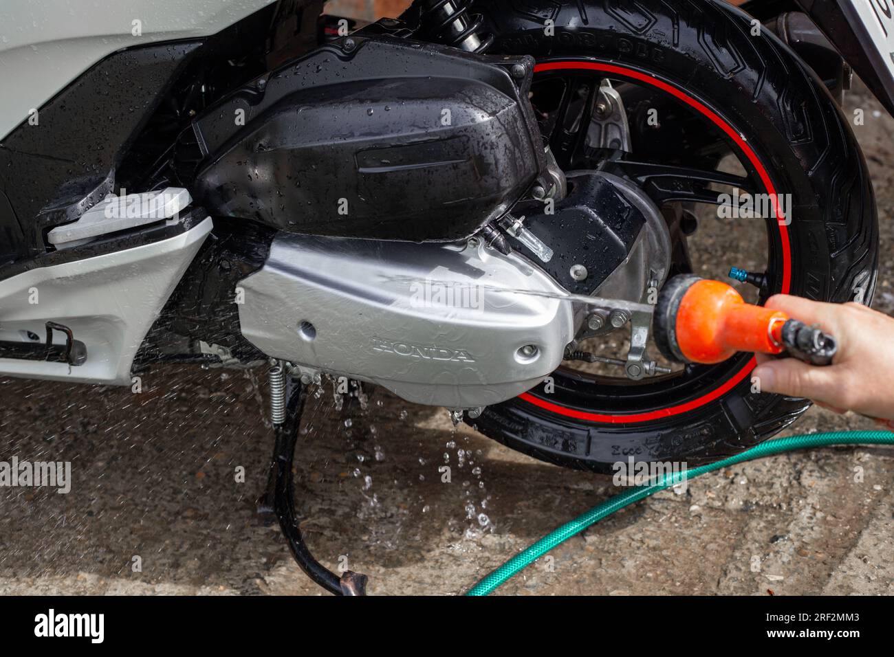 Le propriétaire lave sa moto Honda avec de l'eau provenant d'un tuyau. Anapa, Russie-04.10.2022 Banque D'Images