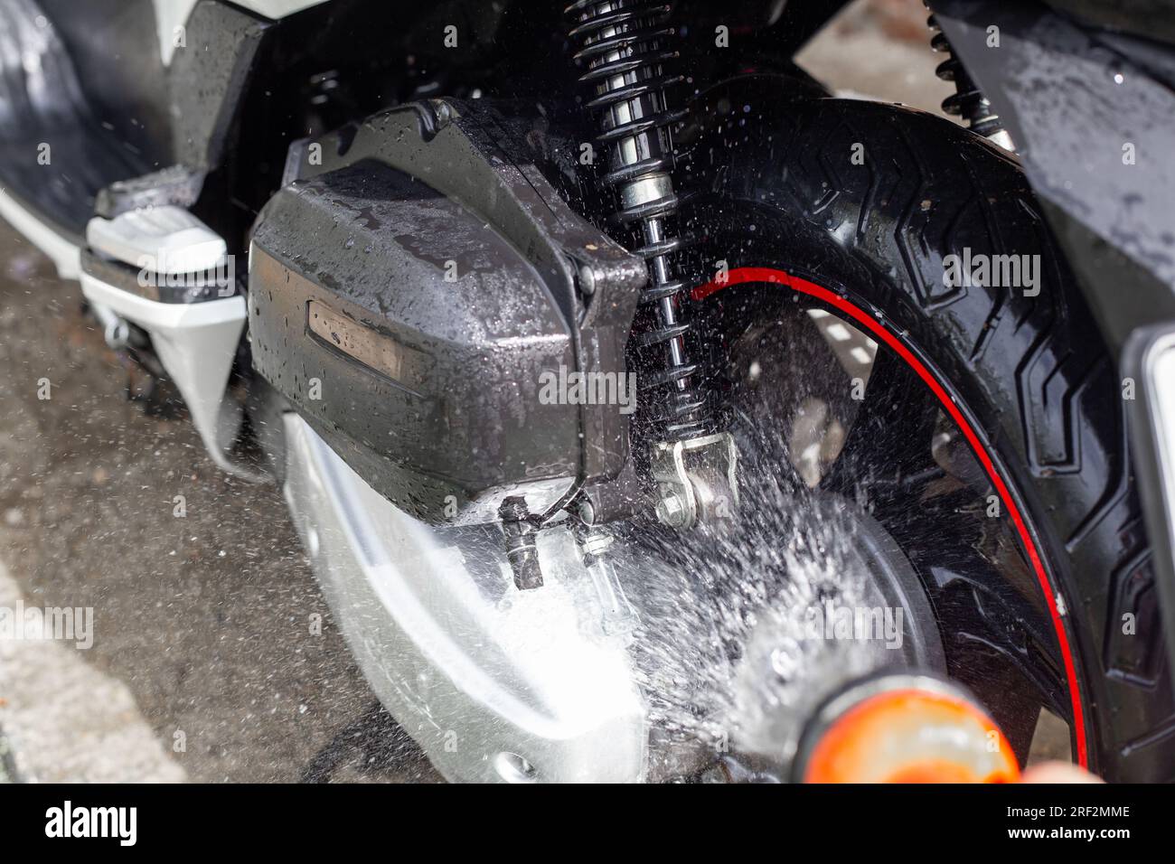 Le propriétaire lave sa moto Honda avec de l'eau provenant d'un tuyau. Anapa, Russie-04.10.2022 Banque D'Images