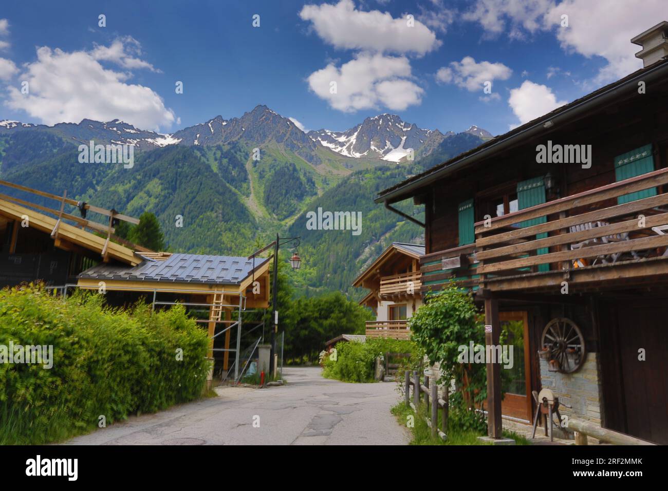 France, Chamonix, haute-Savoie – Chalets alpins traditionnels dans un village de montagne avec des fleurs et des montagnes en arrière-plan, Alpes françaises. Banque D'Images