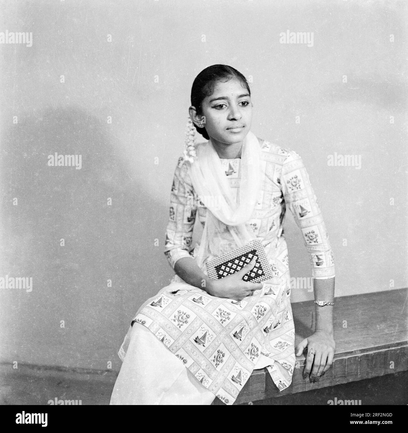 Vieux vintage des années 1900 photo de studio noir et blanc de fille indienne portant salwar kameez main main hair fleur Inde des années 1940 Banque D'Images