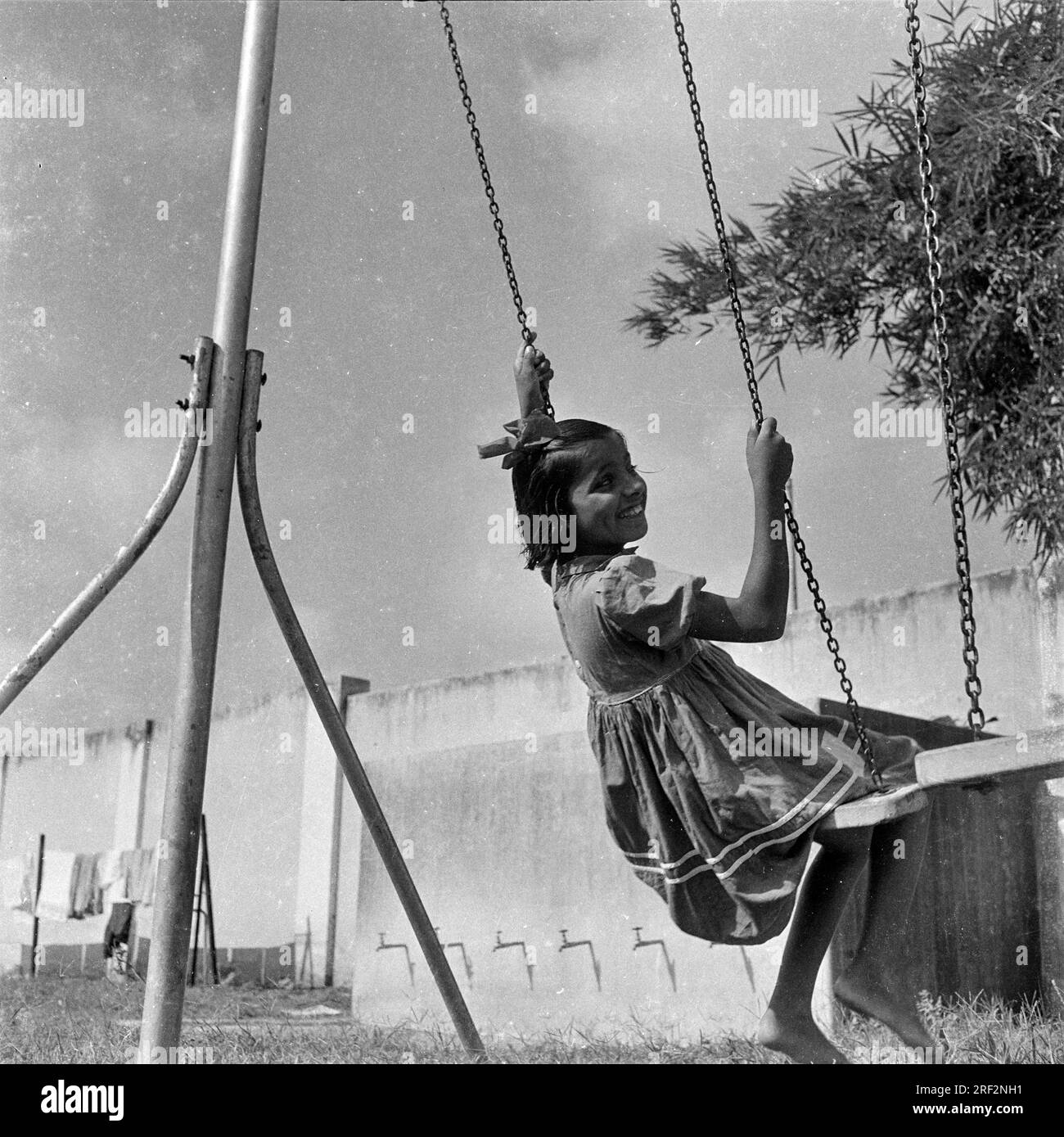 Vieux vintage des années 1900 photo noir et blanc de l'enfant fille indienne sur balançoire enfants terrain de jeu Inde des années 1940 Banque D'Images