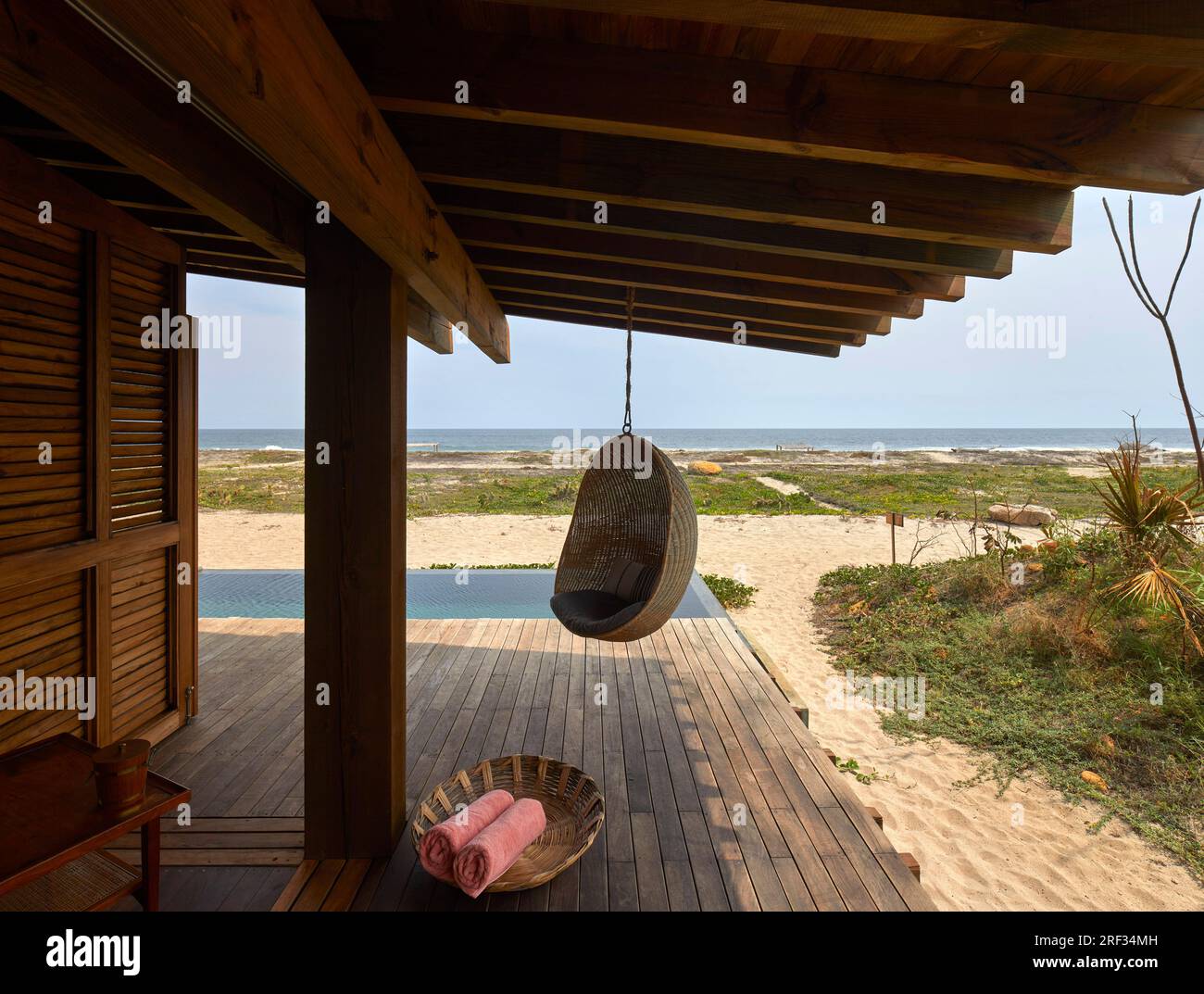 Terrasse en bois avec vue de la piscine à l'océan. Punta Pajaros, Oaxaca, Mexique. Architecte : Alberto Kalach, 2019. Banque D'Images