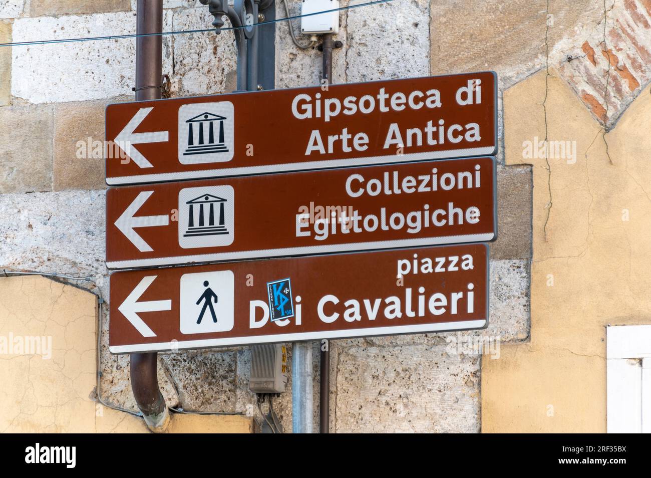 Un panneau touristique de couleur brune placé à de nombreuses attractions touristiques, dans la ville de Pise dans la région toscane de l'Italie Banque D'Images