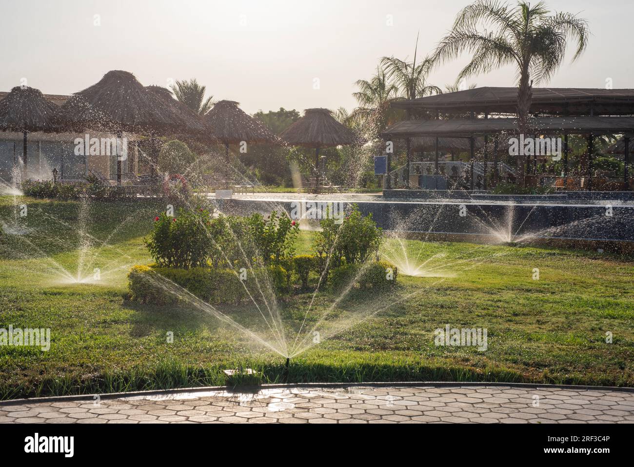 Vue panoramique sur le paysage de la campagne rurale parc public espace extérieur avec gicleurs d'eau sur dans le jardin ornemental tropical Banque D'Images