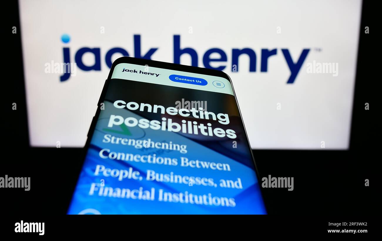 Téléphone mobile avec page Web de la société financière américaine Jack Henry Associates Inc. Sur l'écran devant le logo. Effectuez le focus sur le coin supérieur gauche de l'écran du téléphone. Banque D'Images