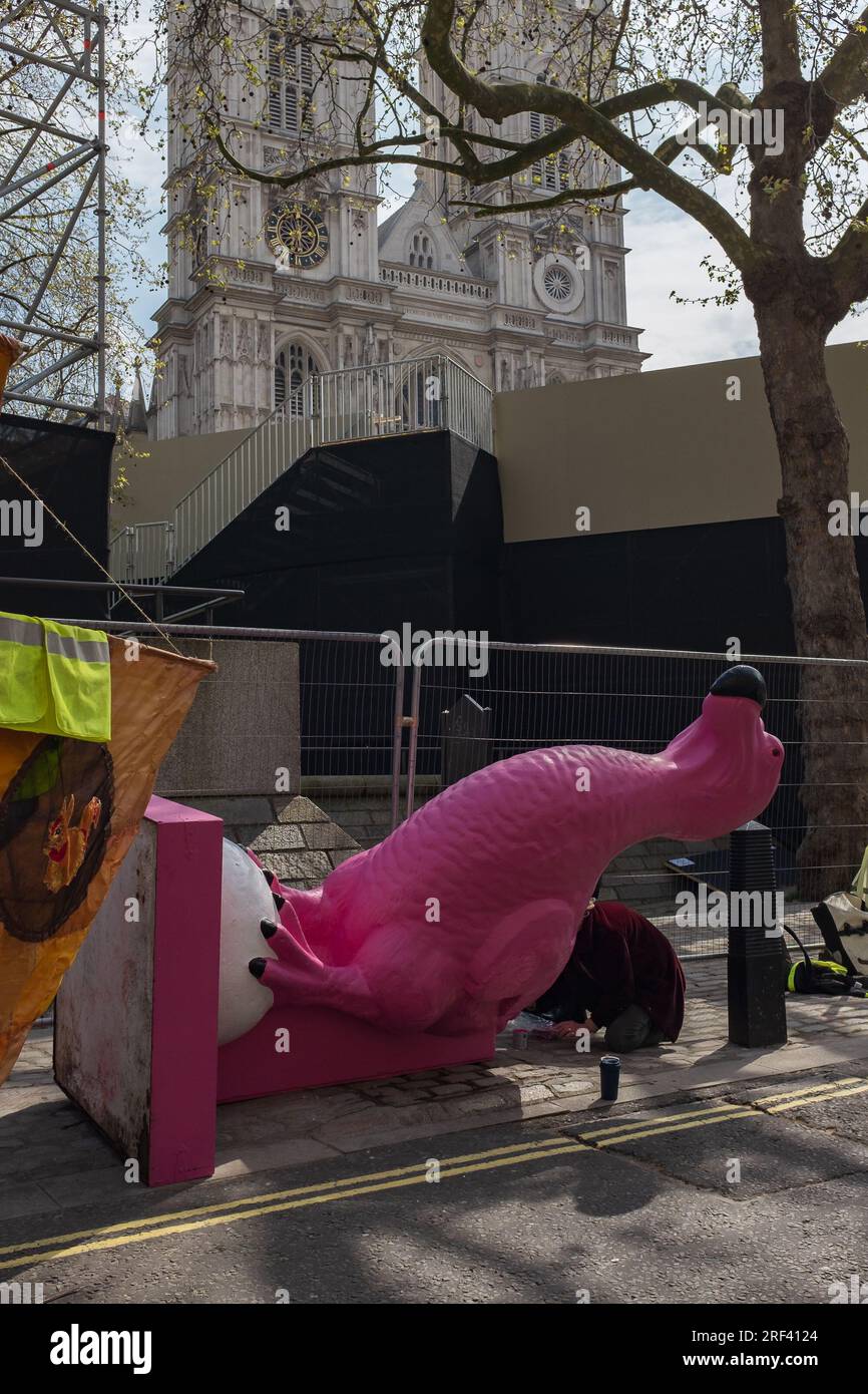 Londres, Royaume-Uni, 2023. Le jour de la Terre, un activiste peint le dodo rose d'extinction Rebellion, avec l'abbaye de Westminster en arrière-plan Banque D'Images