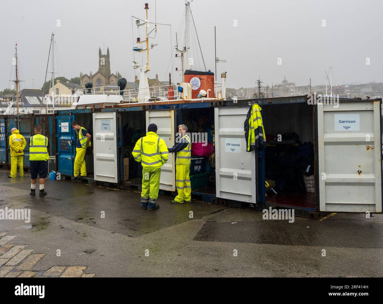 Dockers attendant de charger des bagages pour se rendre à Isles of Scilly, Penzance Harbour, Cornwall, Angleterre, Royaume-Uni, GO. Banque D'Images