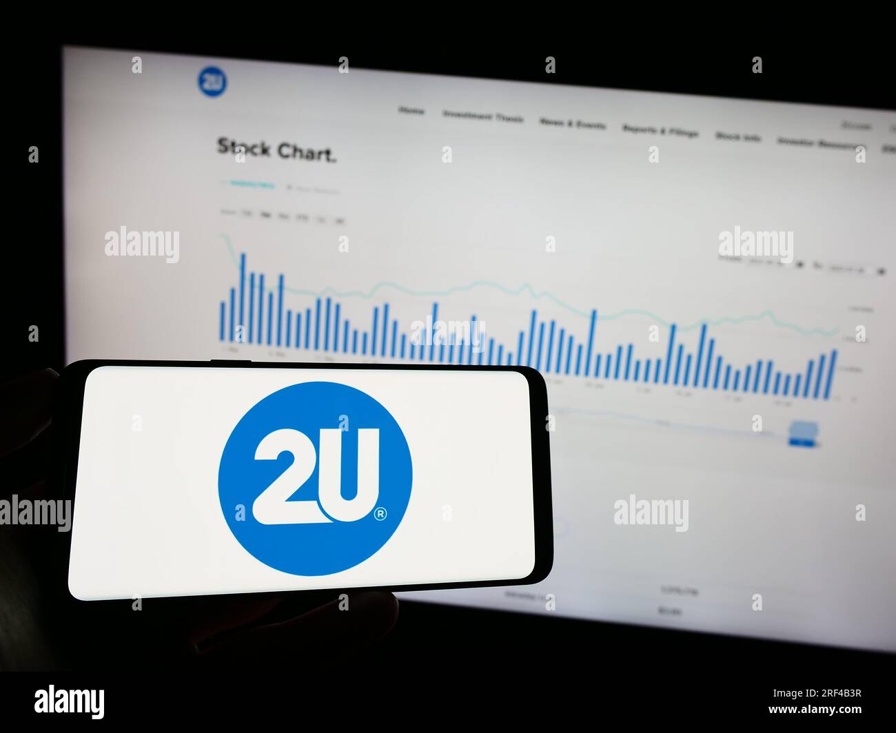 Personne tenant un téléphone mobile avec le logo de la société de technologie éducative américaine 2U Inc. Sur l'écran devant la page Web de l'entreprise. Concentrez-vous sur l'affichage du téléphone. Banque D'Images