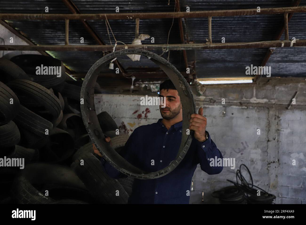 Gaza. 11 juillet 2023. Midian Helles travaille sur le recyclage des pneus dans son petit atelier de la ville de Gaza, le 11 juillet 2023. Crédit : Rizek Abdeljawad/Xinhua/Alamy Live News Banque D'Images