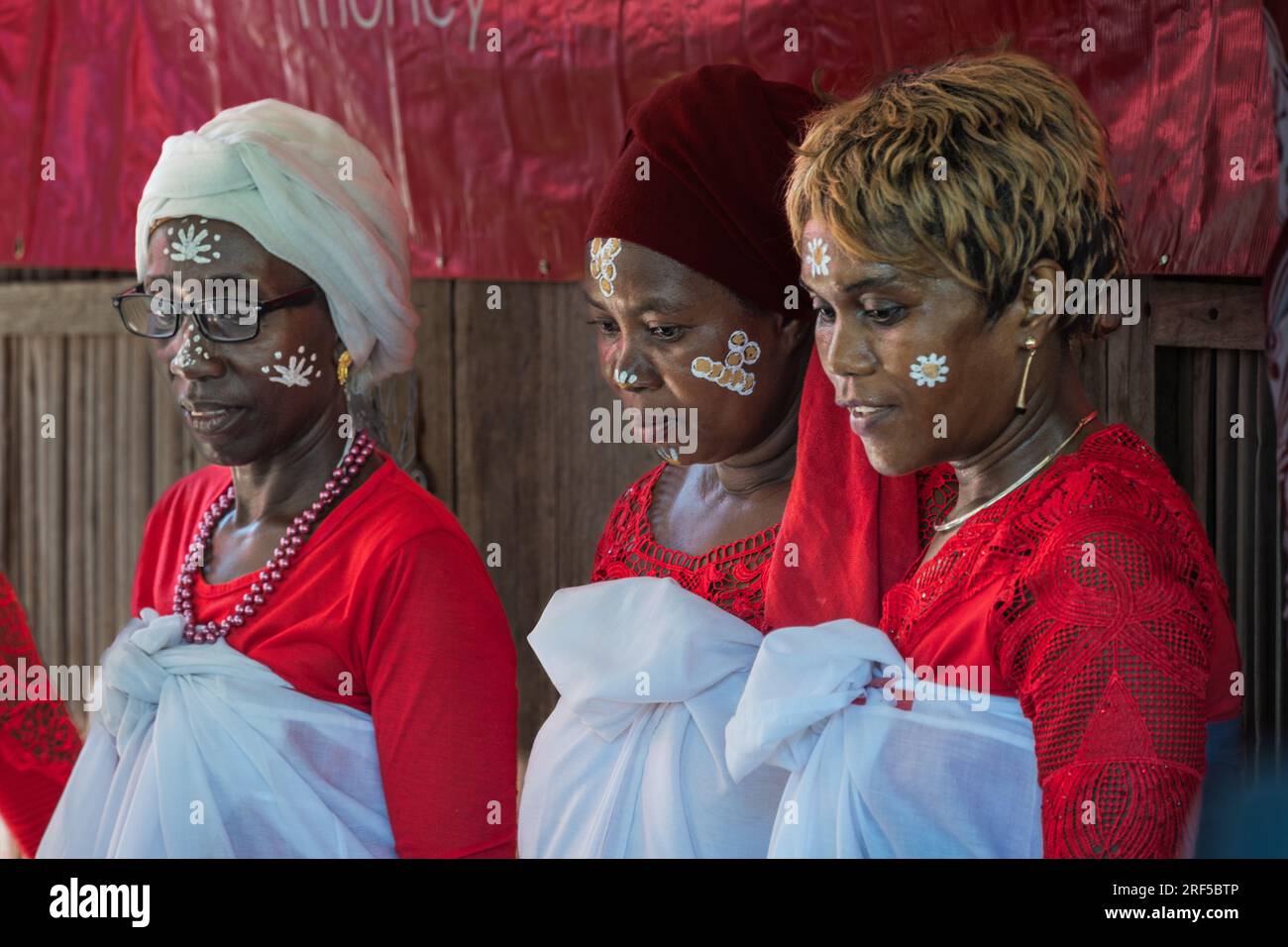 Nosy Be, Madagaascar -- 27 avril 2023. Portrait environnemental de trois femmes avec maquillage traditionnel du visage malgache. Banque D'Images