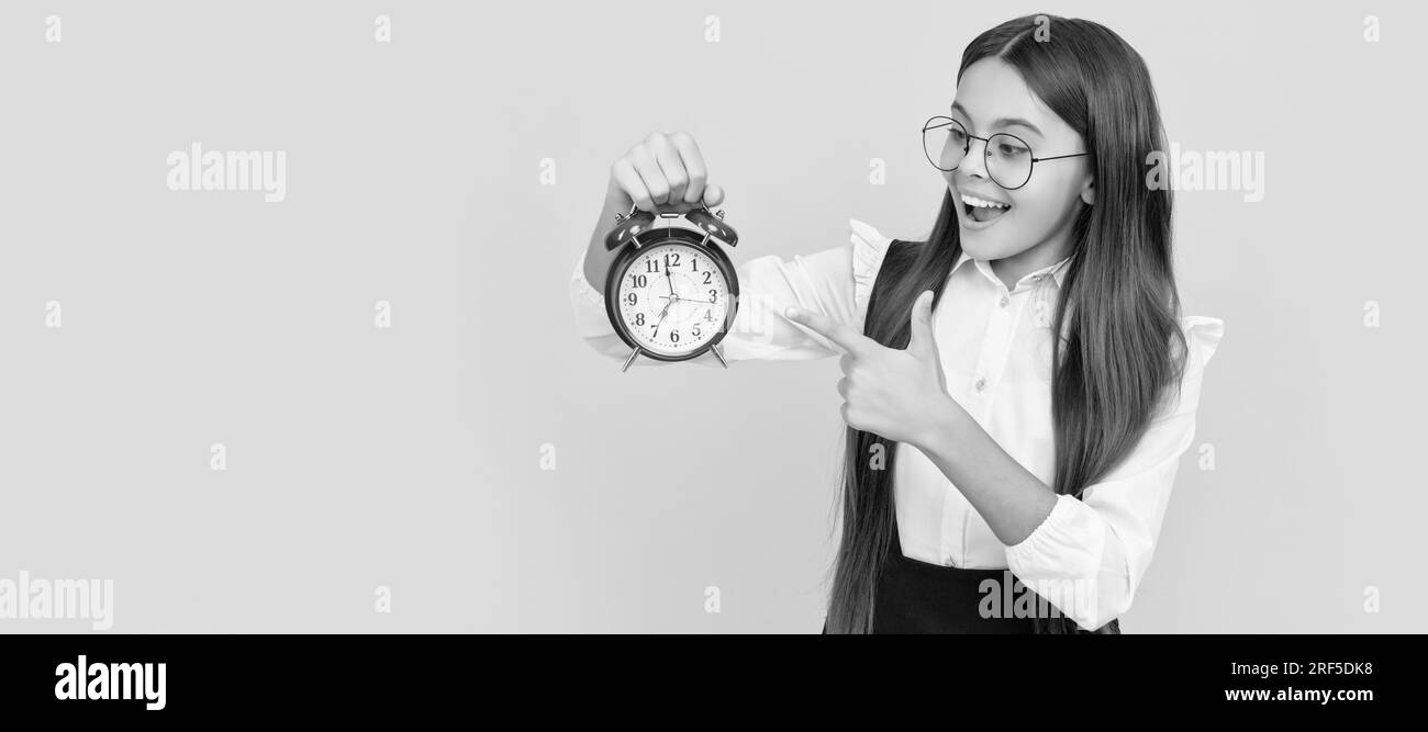 heure de vérification ponctuelle de jeune fille. heureux nerd enfant pointant le doigt sur le réveil. Enfant adolescent avec réveil, affiche horizontale. En-tête de bannière Banque D'Images