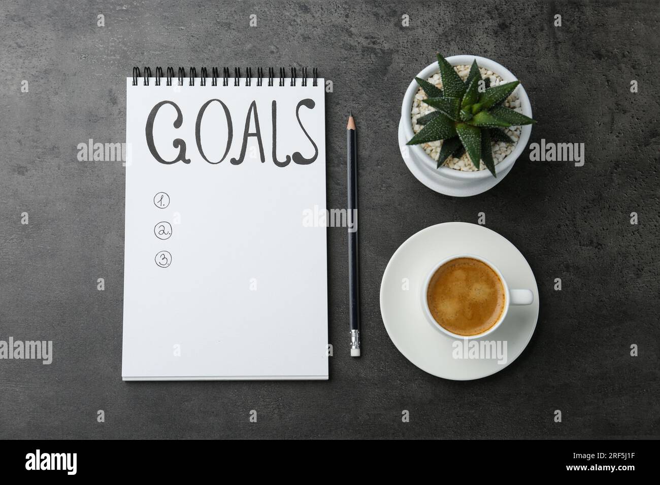 Concept de planification. Liste vide d'objectifs dans le cahier et le café sur fond gris, plat Banque D'Images