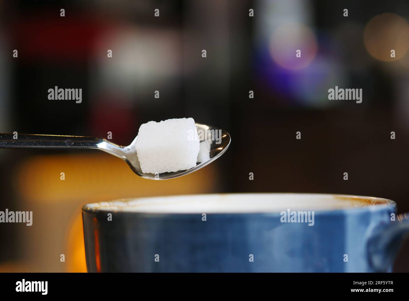 verser le cube de sucre blanc dans une tasse à café Banque D'Images