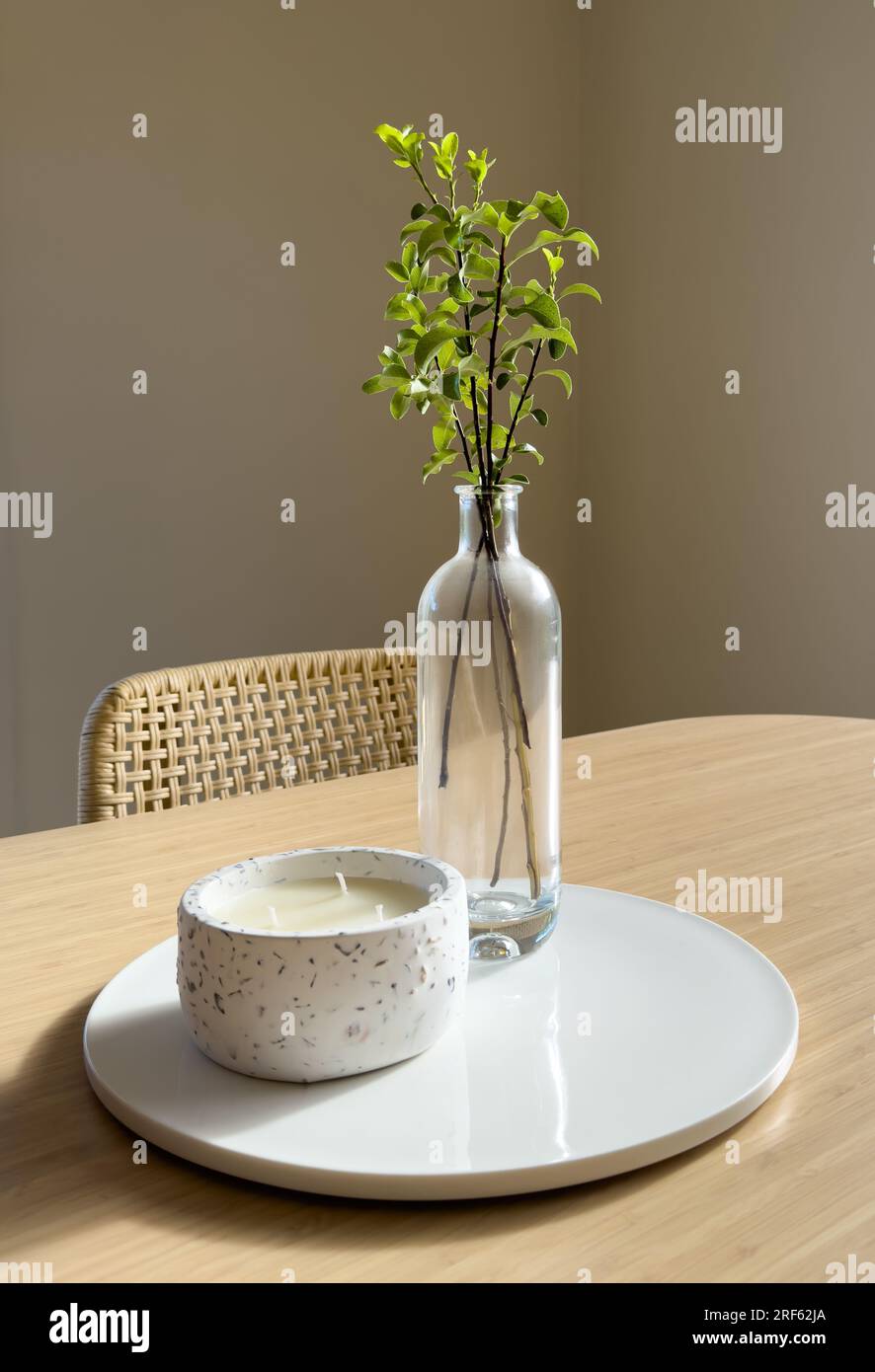 Style scandinave moderne nature morte de vase en verre avec des feuilles vertes et bougie sur un dessus de table en bambou avec espace de copie Banque D'Images