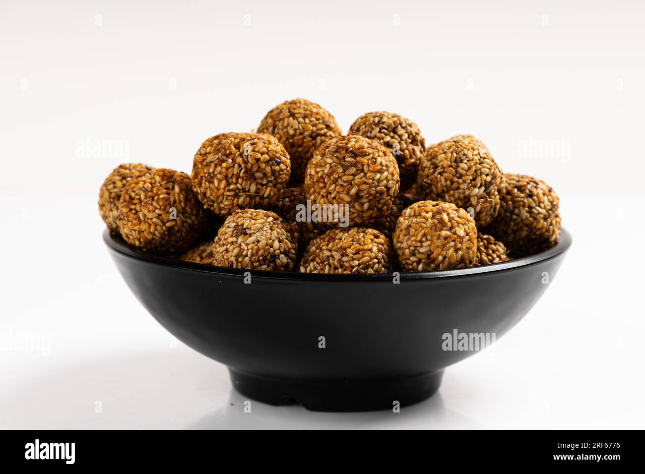 Sesame Ladoo ou Ellunda ou Til ladoo, une friandise indienne traditionnelle à base de graines de sésame et de jaggery, image isolée avec fond blanc. Banque D'Images