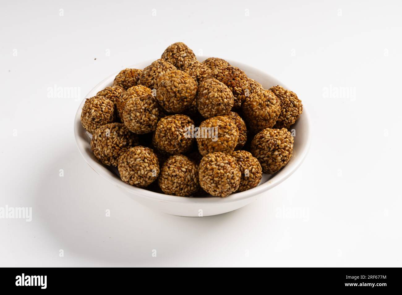 Sesame Ladoo ou Ellunda ou Til ladoo, une friandise indienne traditionnelle à base de graines de sésame et de jaggery, image isolée avec fond blanc. Banque D'Images