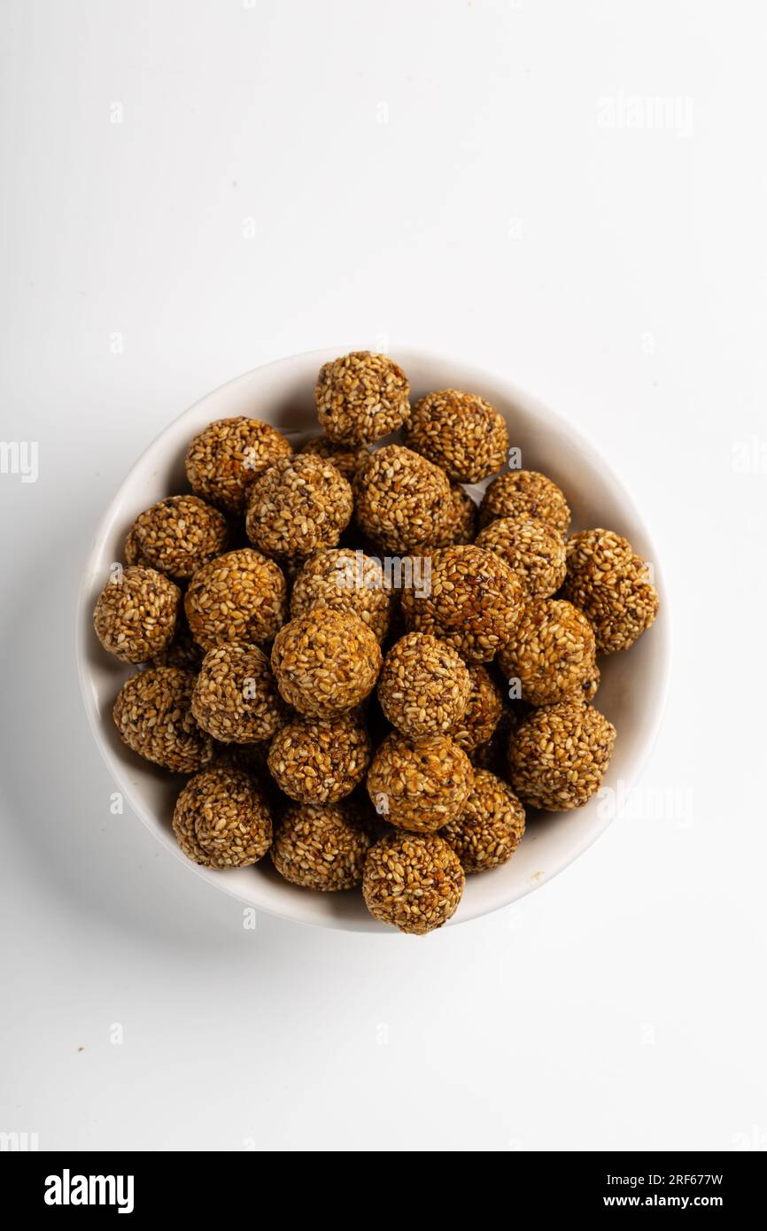 Sesame Ladoo ou Ellunda ou Til ladoo, une friandise indienne traditionnelle à base de graines de sésame et de jaggery, image isolée avec fond blanc. Banque D'Images