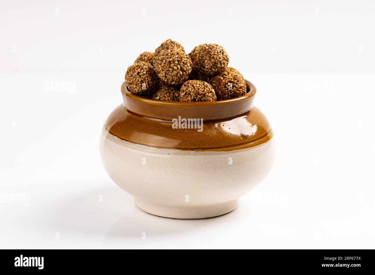 Sesame Ladoo ou Ellunda ou Til ladoo, une friandise indienne traditionnelle à base de graines de sésame et de jaggery, image isolée avec fond blanc. Banque D'Images