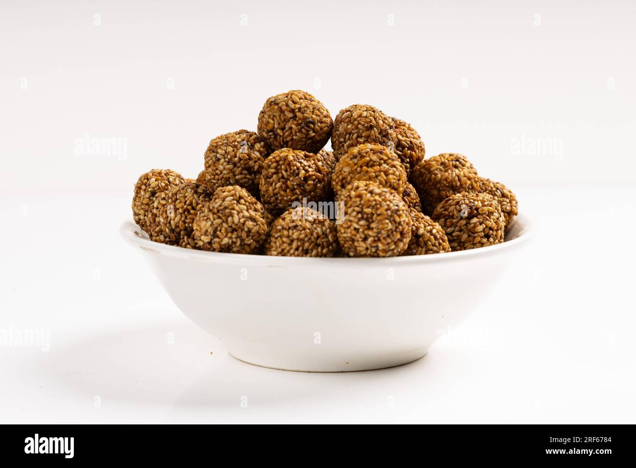Sesame Ladoo ou Ellunda ou Til ladoo, une friandise indienne traditionnelle à base de graines de sésame et de jaggery, image isolée avec fond blanc. Banque D'Images