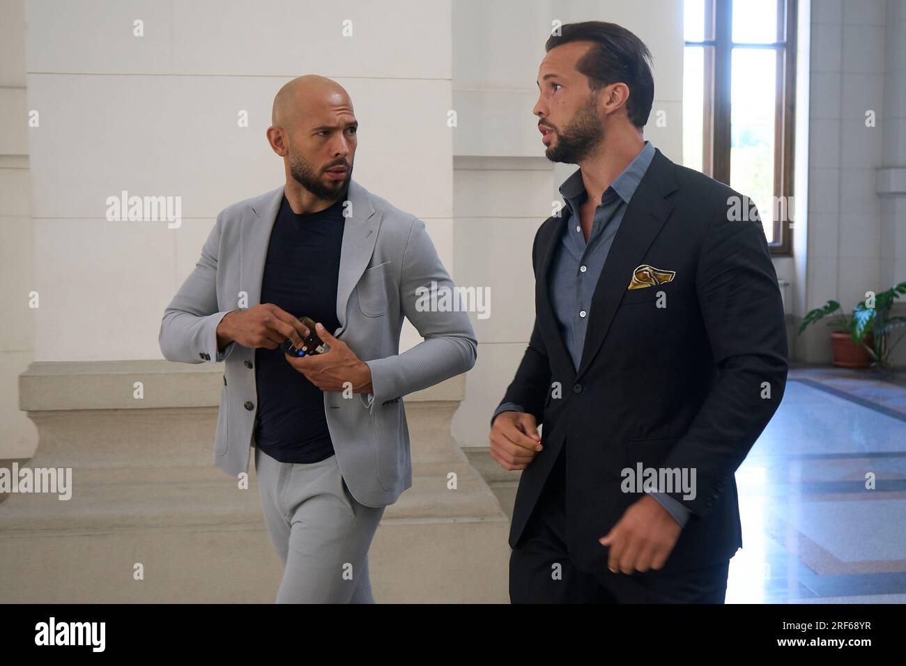 Bucarest, Roumanie. 1 août 2023 : Andrew Tate (à gauche) et son frère Tristan Tate (à droite) arrivent à la Cour d'appel de Bucarest qui juge leur appel contre l'assignation à résidence. Les frères Tate sont accusés dans une affaire de traite d'êtres humains et de formation d'un groupe criminel organisé pour l'exploitation des femmes. Ils ont d'abord été détenus pendant 24 heures le 29 décembre 2022, le lendemain, les juges ont décidé d'une arrestation préventive et, plus tard, le 31 mars 2023, ils ont été assignés à résidence. Crédit : Lucian Alecu/Alamy Live News Banque D'Images