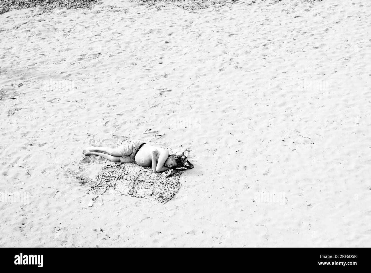 L'homme de dormir sur la plage Banque D'Images