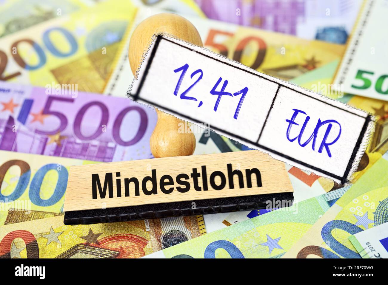 FOTOMONTAGE, Stempel mit Aufschrift Mindestlohn und Zettel mit Aufschrift 12,41 EUR auf Geldscheinen Banque D'Images