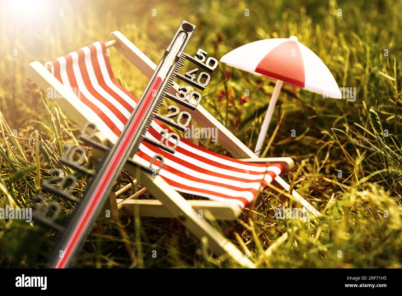 Liegestuhl, Sonnenschirm und Thermometer auf vertrocknetem gras, Symbolfoto Hitzewelle Banque D'Images