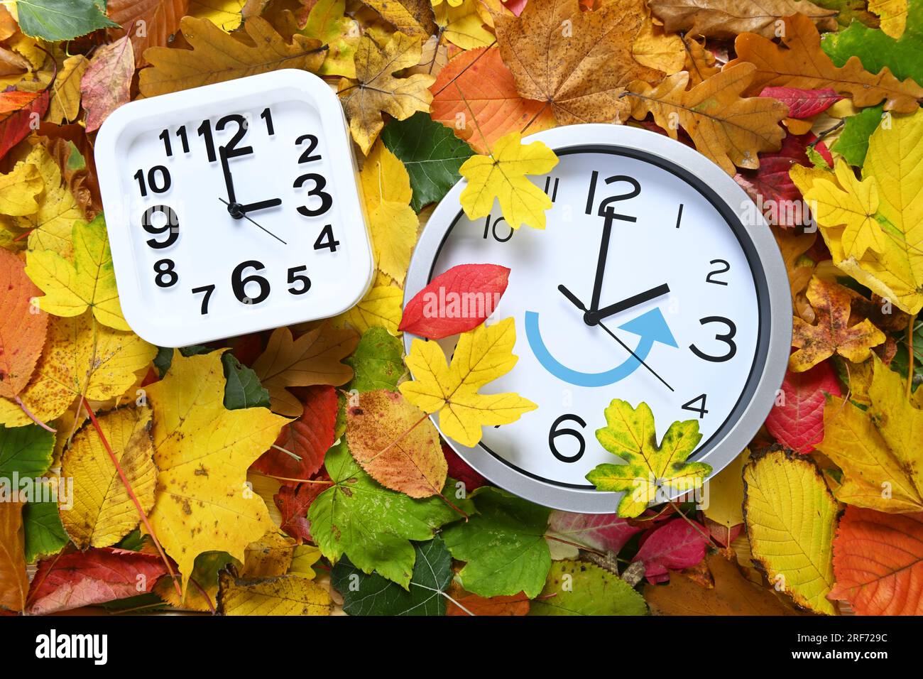 FOTOMONTAGE, Uhr auf Herbstblättern, Symbolfoto für die Umstellung auf Winterzeit Banque D'Images