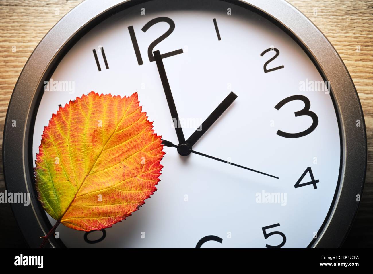 Herbstblatt auf Uhr, Symbolfoto für die Rückstellung auf Winterzeit Banque D'Images