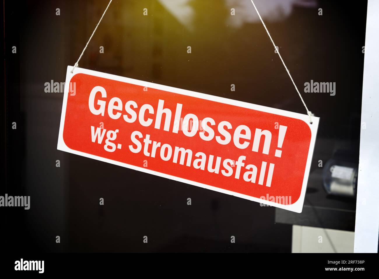 FOTOMONTAGE, Schild mit der Aufschrift geschlossen wg. Stromausfall hängt an einer Glastür Banque D'Images