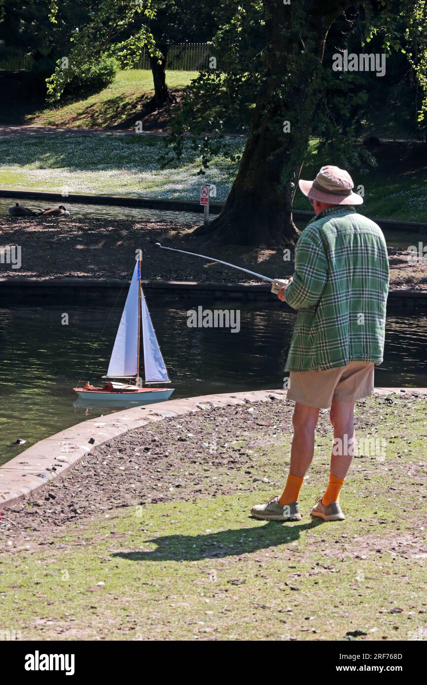 Homme mature avec yacht à télécommande sur l'étang dans Pavilion Gardens, Buxton Banque D'Images