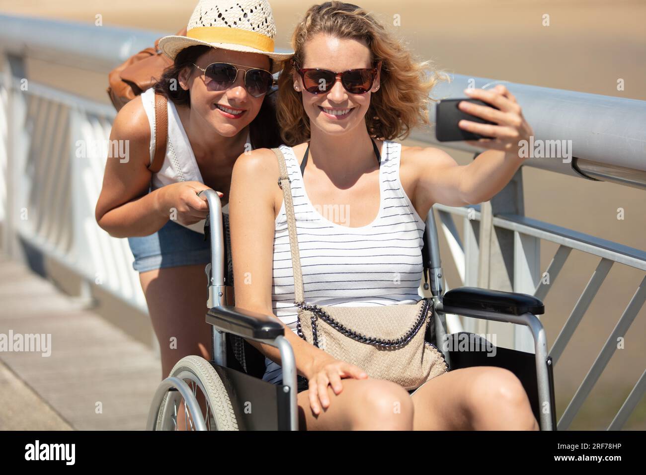 femme en fauteuil roulant prenant selfie avec un ami Banque D'Images