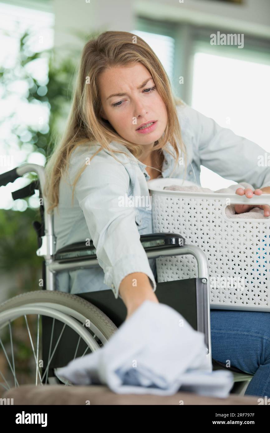 femme sur le fauteuil roulant atteignant le tissu Banque D'Images