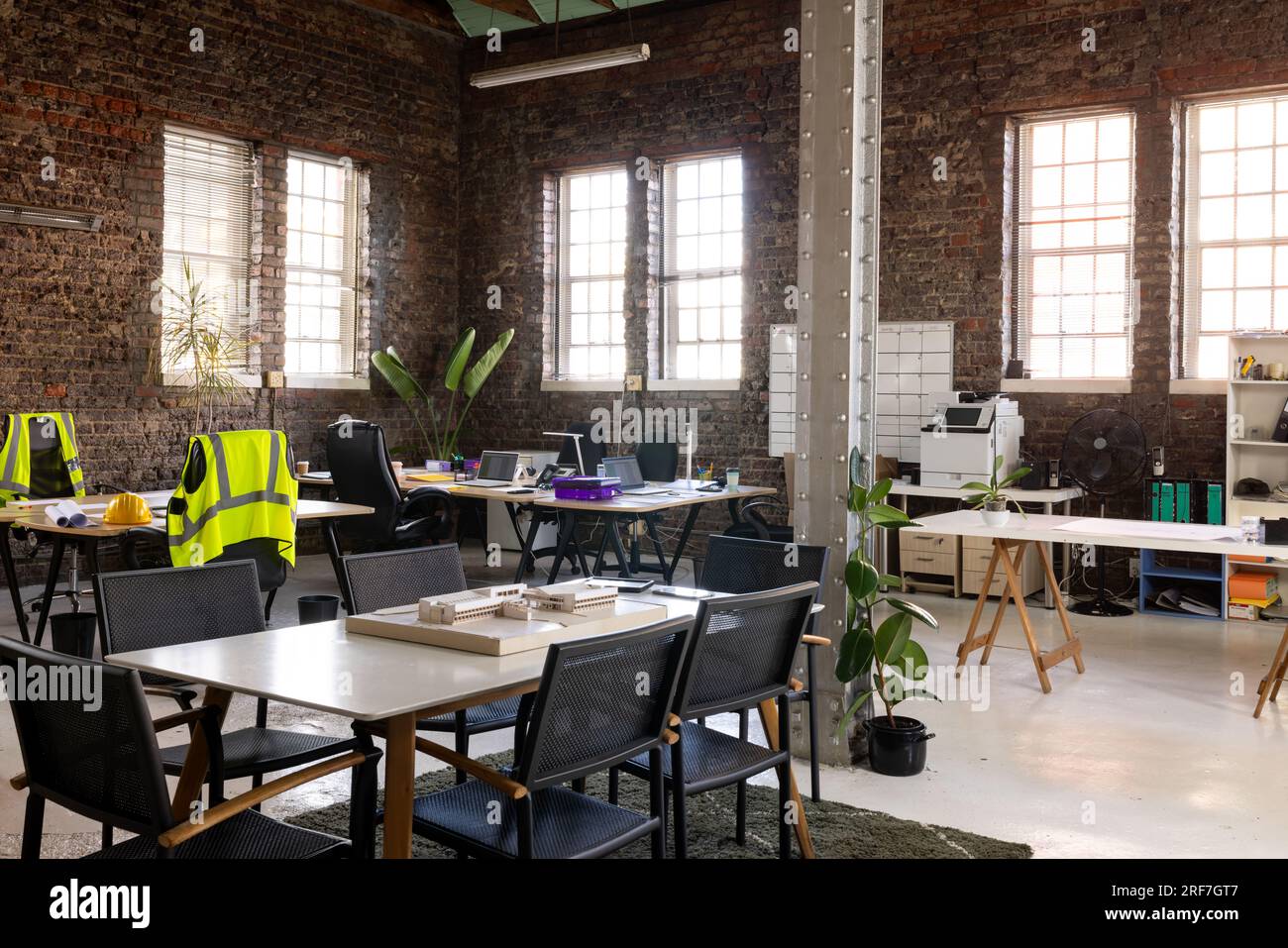 Intérieur de bureau moderne et créatif avec murs en briques apparentes, bureaux et chaises Banque D'Images