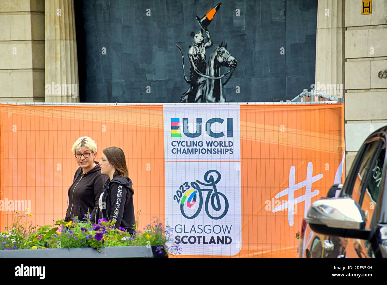 Glasgow, Écosse, Royaume-Uni 31 juillet 2023. Des barrières anti-terroristes UCI sont installées pour les championnats du monde dans les rues de la ville et canalisent les foules pour la vérification des bagages avec la circulation et les barrières. Banksie cône tête Duke Tribute sur Argyle Street lève son chapeau à la foule de l'uci. Crédit Gerard Ferry/Alamy Live News Banque D'Images