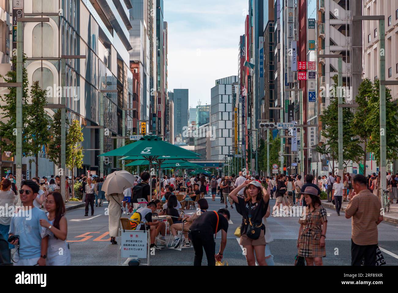 TOKYO, JAPON - JUILLET 30 2023 : les acheteurs empruntent les routes fermées de Ginza, le quartier de luxe du centre de Tokyo Banque D'Images