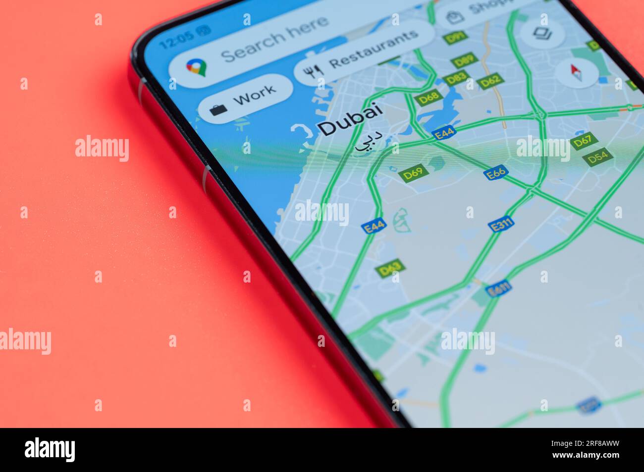 New York, États-Unis - 21 juillet 2023 : distribution du trafic automobile de Dubaï dans google maps sur écran smartphone vue rapprochée avec fond rouge Banque D'Images
