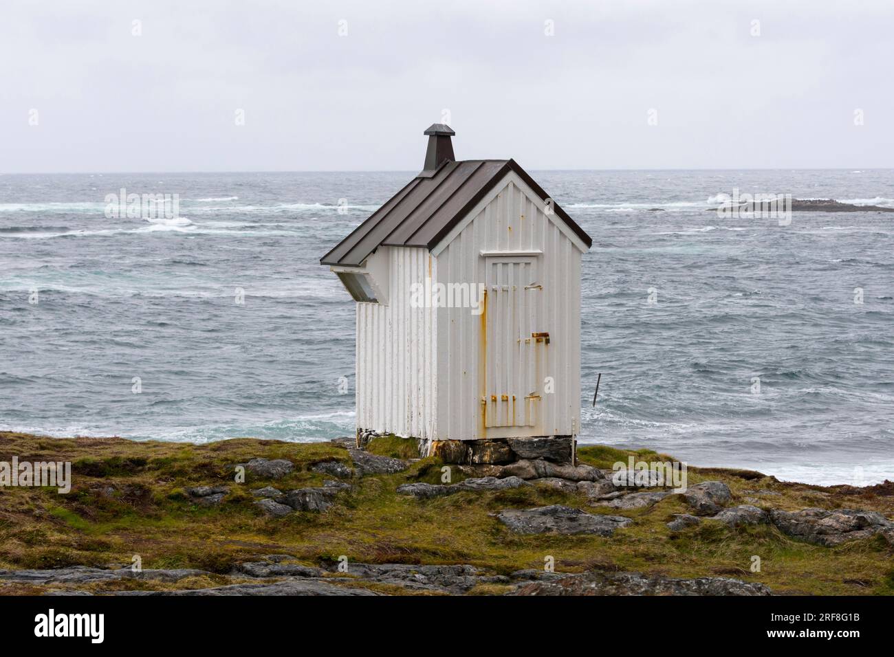 Petite maison blanche à côté de Børhella fyr brave le vent et la mer orageuse. Nøss, Andenes, Andøya, Vesterålen, Nordland, Norvège du Nord Banque D'Images