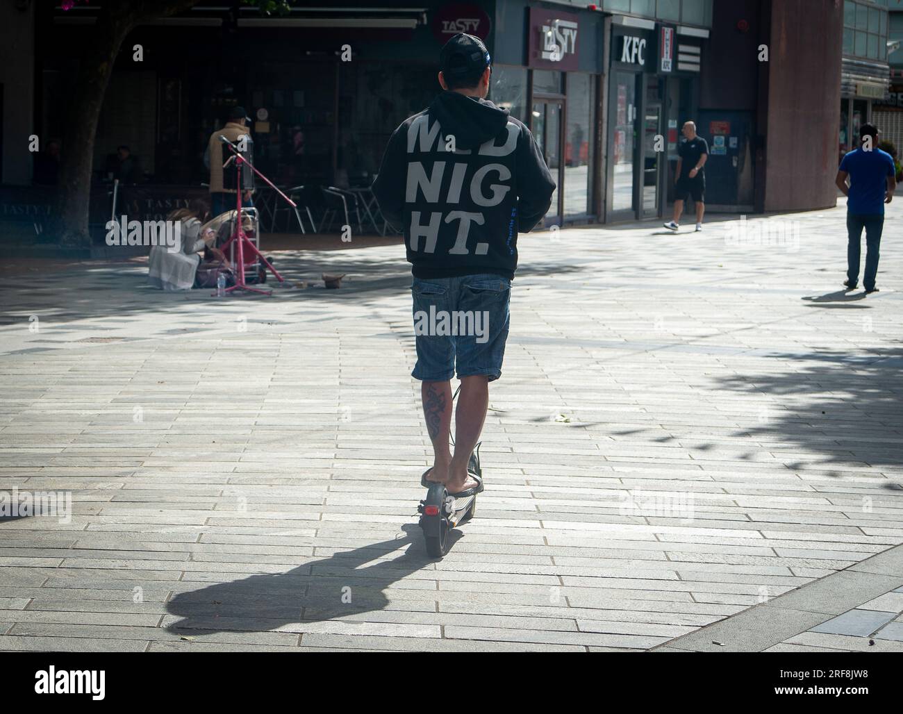 Slough, Berkshire, Royaume-Uni. 1 août 2023. Un homme conduit un scooter électrique dans le centre-ville de Slough. Il y a des appels pour un examen approfondi de la sécurité des e scooters suite à un certain nombre de décès causés par des incendies lors de la recharge des batteries e scooter. Crédit : Maureen McLean/Alamy Banque D'Images