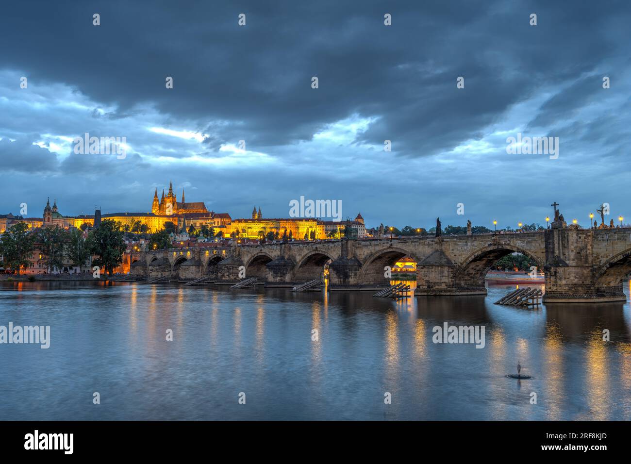 Le château et le célèbre pont Charles à Prague au crépuscule avec des nuages sombres dans le ciel Banque D'Images