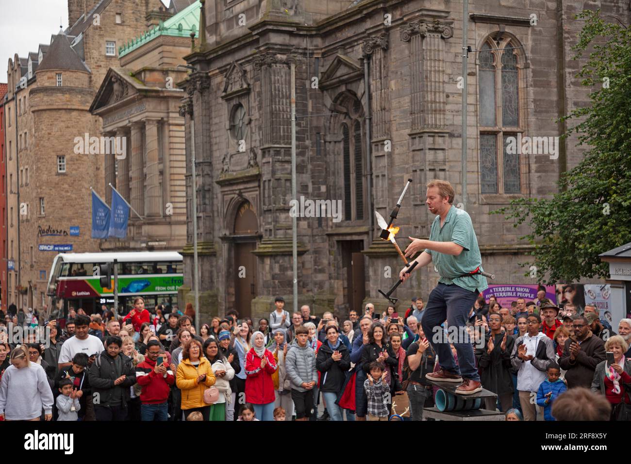 Royal Mile, High Street, Édimbourg, Écosse, Royaume-Uni. 1 août 2023. Quiconque se promenait dans High Street aurait pu croire que le Festival Fringe d'Édimbourg avait déjà commencé alors qu'un grand public cosmopolite se réunissait pour regarder les artistes de rue professionnels à l'heure du thé. Sur la photo : Daniel Zindler jongle des clubs et des torches de feu à un public reconnaissant. Crédit : Awhite/alamy Live News. Banque D'Images